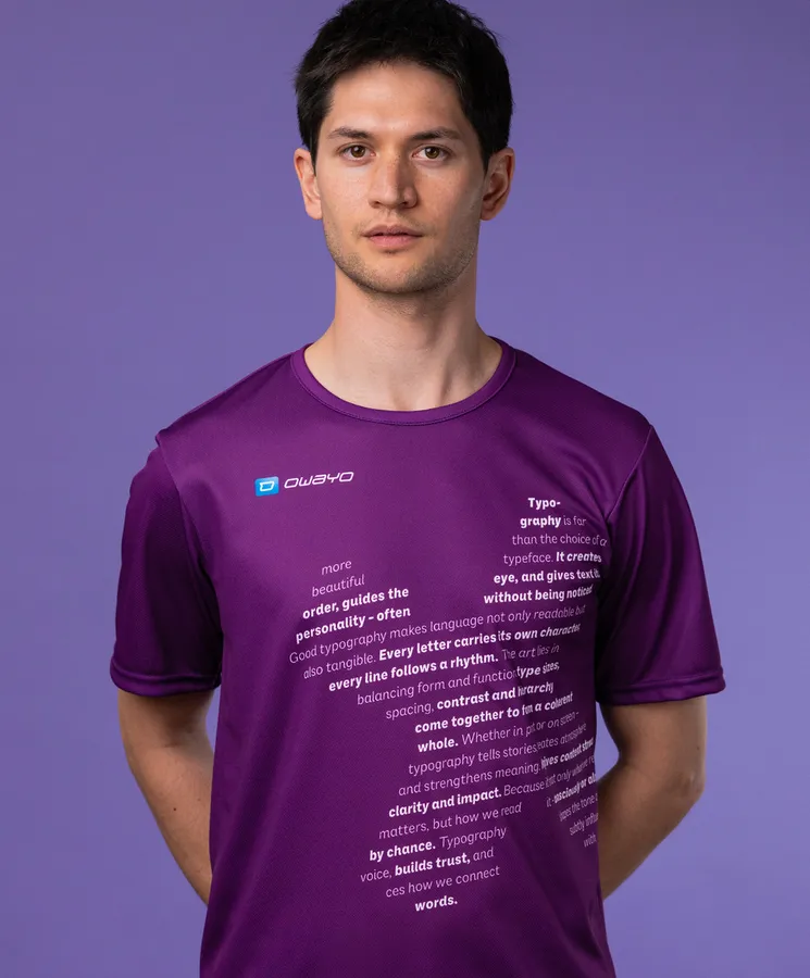 A man is wearing a purple sports shirt featuring typographic text on the front, set against a purple background.